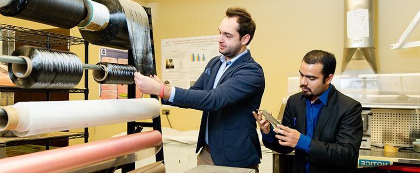 Professor and student working in lab with rolling material